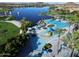 Aerial view of the community pool and lake, featuring palm trees, lounge chairs and a play area at 13216 S 175 Dr, Goodyear, AZ 85338