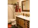 Bathroom featuring wood-look vanity, decorative mirror, and bathtub at 13216 S 175 Dr, Goodyear, AZ 85338