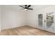 Bright bedroom features vinyl wood flooring, a ceiling fan, and a glass panel door leading to the outside at 13244 N 54Th Dr, Glendale, AZ 85304