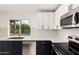 Close-up of modern kitchen with white cabinets, stainless steel appliances, and stylish fixtures at 13244 N 54Th Dr, Glendale, AZ 85304