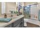 Well-lit bathroom featuring glass shower and vanity with gray cabinets at 1345 E Gaffney Rd, New River, AZ 85087