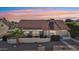 Rear exterior view showcasing covered patio with block privacy wall and well-maintained tile roof at 13942 W Summerstar Dr, Sun City West, AZ 85375