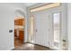 Bright entryway with wood floors and a view of the kitchen through an arched doorway at 13942 W Summerstar Dr, Sun City West, AZ 85375