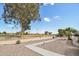 Scenic view of greenspace featuring desert landscaping, mature trees, and distant views of community homes at 13942 W Summerstar Dr, Sun City West, AZ 85375