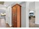 Hallway with wooden cabinet for storage, white walls and views to a bright living space at 13942 W Summerstar Dr, Sun City West, AZ 85375