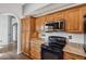 Beautiful kitchen with granite countertops, wood cabinets, and black appliances at 13942 W Summerstar Dr, Sun City West, AZ 85375