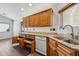 Well-lit kitchen featuring wood cabinets, granite countertops, and modern appliances at 13942 W Summerstar Dr, Sun City West, AZ 85375