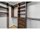 Organized walk-in closet with dark wood shelving and drawers, providing ample storage space at 13942 W Summerstar Dr, Sun City West, AZ 85375