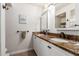 The primary bathroom features dual sinks with stone countertops and white cabinets and black hardware at 14042 N 44Th St, Phoenix, AZ 85032