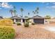 Charming ranch-style home with desert landscaping and a two-car garage, complemented by mature palm trees at 14042 N 44Th St, Phoenix, AZ 85032