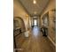 Hallway featuring wood floors, mirrors, and light-filled view of rooms further inside of the home at 1511 E Lynx Way, Gilbert, AZ 85298