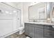 Modern bathroom features walk-in shower with glass door, granite countertop, and grey cabinets at 1547 E Crescent Way, Gilbert, AZ 85298