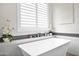 Inviting tub with stylish fixtures and mosaic tile backsplash and plantation shutters at 1547 E Crescent Way, Gilbert, AZ 85298