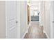 Hallway with wood-style flooring leading to the ensuite bathroom with neutral decor at 1547 E Crescent Way, Gilbert, AZ 85298