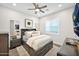 Comfortable bedroom with wood-look tile flooring, ceiling fan, and abundant natural light at 1547 E Crescent Way, Gilbert, AZ 85298