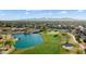 Stunning aerial view showcasing the golf course, lake, community, and mountain views at 16253 W Windcrest Dr, Surprise, AZ 85374