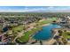 Panoramic aerial view of the community featuring a lush golf course, lake, desert landscaping and mountain views at 16253 W Windcrest Dr, Surprise, AZ 85374