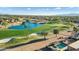 An aerial view highlighting the golf course adjacent to the home, a small lake, and a pool at 16253 W Windcrest Dr, Surprise, AZ 85374