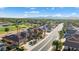 A community street lined with homes, lush landscaping, a golf course, and mountain views at 16253 W Windcrest Dr, Surprise, AZ 85374