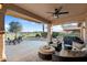 Inviting covered back patio featuring comfortable seating, a ceiling fan, and golf course views perfect for outdoor relaxation at 16253 W Windcrest Dr, Surprise, AZ 85374