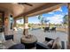 Covered patio area with comfortable seating and pool overlooking green space at 16253 W Windcrest Dr, Surprise, AZ 85374