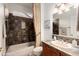 Cozy bathroom featuring decorative tile, neutral walls, framed mirror, tub and shower combo, and beige fixtures at 16253 W Windcrest Dr, Surprise, AZ 85374