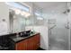 This bathroom features black granite countertops, tile walls, and a glass shower enclosure at 16253 W Windcrest Dr, Surprise, AZ 85374