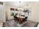 Elegant dining room with modern chandelier, wood table, and views of the landscaped yard at 16253 W Windcrest Dr, Surprise, AZ 85374