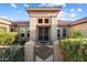 Inviting front entrance featuring decorative pillars, a wrought iron security door, and desert landscaping at 16253 W Windcrest Dr, Surprise, AZ 85374