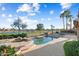 Relaxing pool and spa with golf course view, surrounded by palm trees and lush landscaping creating a serene oasis at 16253 W Windcrest Dr, Surprise, AZ 85374