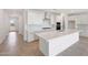 Modern, all-white kitchen featuring stainless steel appliances, quartz countertops, and a large kitchen island at 17253 W Via Dona Rd, Surprise, AZ 85387