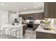 Spacious kitchen with stainless steel appliances, an island with bar seating, and dark wood cabinets at 17742 W Brown St, Waddell, AZ 85355