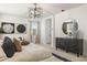 Bright bedroom features a decorative mirror, neutral color palette, and a stylish dresser at 17742 W Brown St, Waddell, AZ 85355