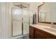 Bathroom features a glass shower, wood vanity, neutral walls, and decorative wall art at 17810 W Club Vista Dr, Surprise, AZ 85374