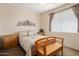 Cozy bedroom with decorative quilt, matching side tables, wood bench, and light peach colored walls at 17810 W Club Vista Dr, Surprise, AZ 85374