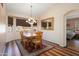 Dining area features a wooden table, decorative chandelier, and outdoor views at 17810 W Club Vista Dr, Surprise, AZ 85374