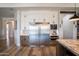 Modern kitchen with stainless steel appliances, granite counters, white cabinets and hardwood floors at 18125 W Montebello Ct # 67, Litchfield Park, AZ 85340
