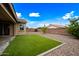 Beautiful backyard featuring an artificial lawn, gravel landscaping, and a vibrant blue sky at 2196 E Brigadier Dr, Gilbert, AZ 85298