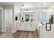 Stylish bathroom with double vanities, white cabinetry, black matte fixtures, and a glass-enclosed shower and tub at 2196 E Brigadier Dr, Gilbert, AZ 85298