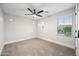 Cozy bedroom featuring plush carpeting, bright windows, and a modern ceiling fan at 2196 E Brigadier Dr, Gilbert, AZ 85298