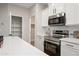 Close-up of the kitchen showcasing stainless steel appliances, white cabinets, quartz countertops, and modern hardware at 2196 E Brigadier Dr, Gilbert, AZ 85298