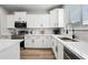 Close-up view of the kitchen featuring stainless steel appliances, white cabinets, quartz countertops, and modern fixtures at 2196 E Brigadier Dr, Gilbert, AZ 85298