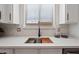 Detailed view of the kitchen sink area with quartz countertops, white cabinets, and modern faucet fixtures at 2196 E Brigadier Dr, Gilbert, AZ 85298