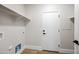 Bright laundry room featuring a white door, shelves, light wood-look flooring, and updated fixtures at 2196 E Brigadier Dr, Gilbert, AZ 85298