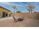 Well-maintained backyard featuring a brick-paved patio with seating and a tall block wall for privacy at 25067 W Dove Trl, Buckeye, AZ 85326