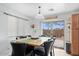 A dining area featuring a wood table, seating for six, tile floors, and a sliding glass door at 25067 W Dove Trl, Buckeye, AZ 85326