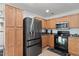 A functional kitchen featuring wood cabinets, stainless steel appliances, and tile flooring at 25067 W Dove Trl, Buckeye, AZ 85326