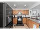 A functional kitchen featuring wood cabinets, granite countertops, stainless steel appliances, and tile flooring at 25067 W Dove Trl, Buckeye, AZ 85326