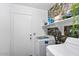 Functional laundry room featuring modern washer and dryer units and stylish rock-patterned wallpaper at 25067 W Dove Trl, Buckeye, AZ 85326