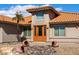 Inviting front entrance showcases unique landscaping and a striking orange door, offering a warm welcome at 2585 Leisure World --, Mesa, AZ 85206